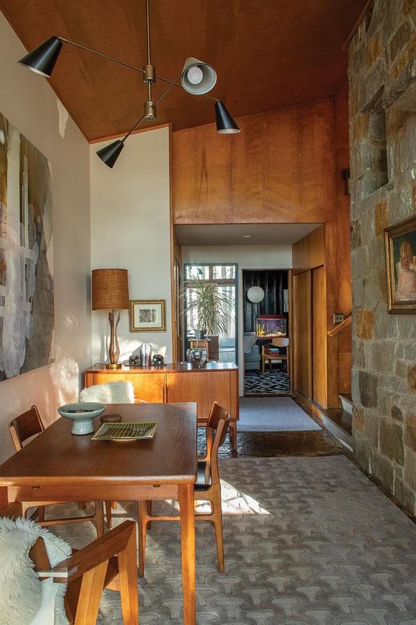 the entry/dining area has a soaring stone chimney and a petrified-wood floor