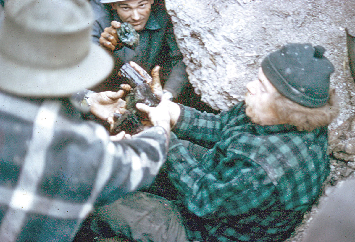 Frank Perham hands muddy crystals up from the floor of a pocket.