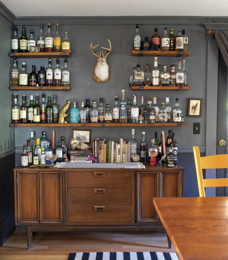 a mid-century-style sideboard outfitted with bottles of alcohol and bar supplies